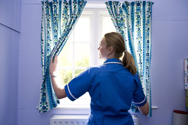 End of life, carer closing a curtain