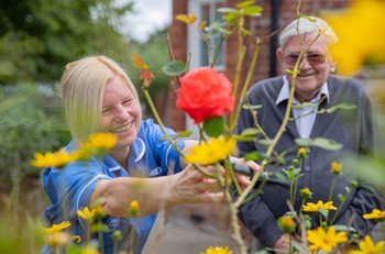 care assistant with customer in garden
