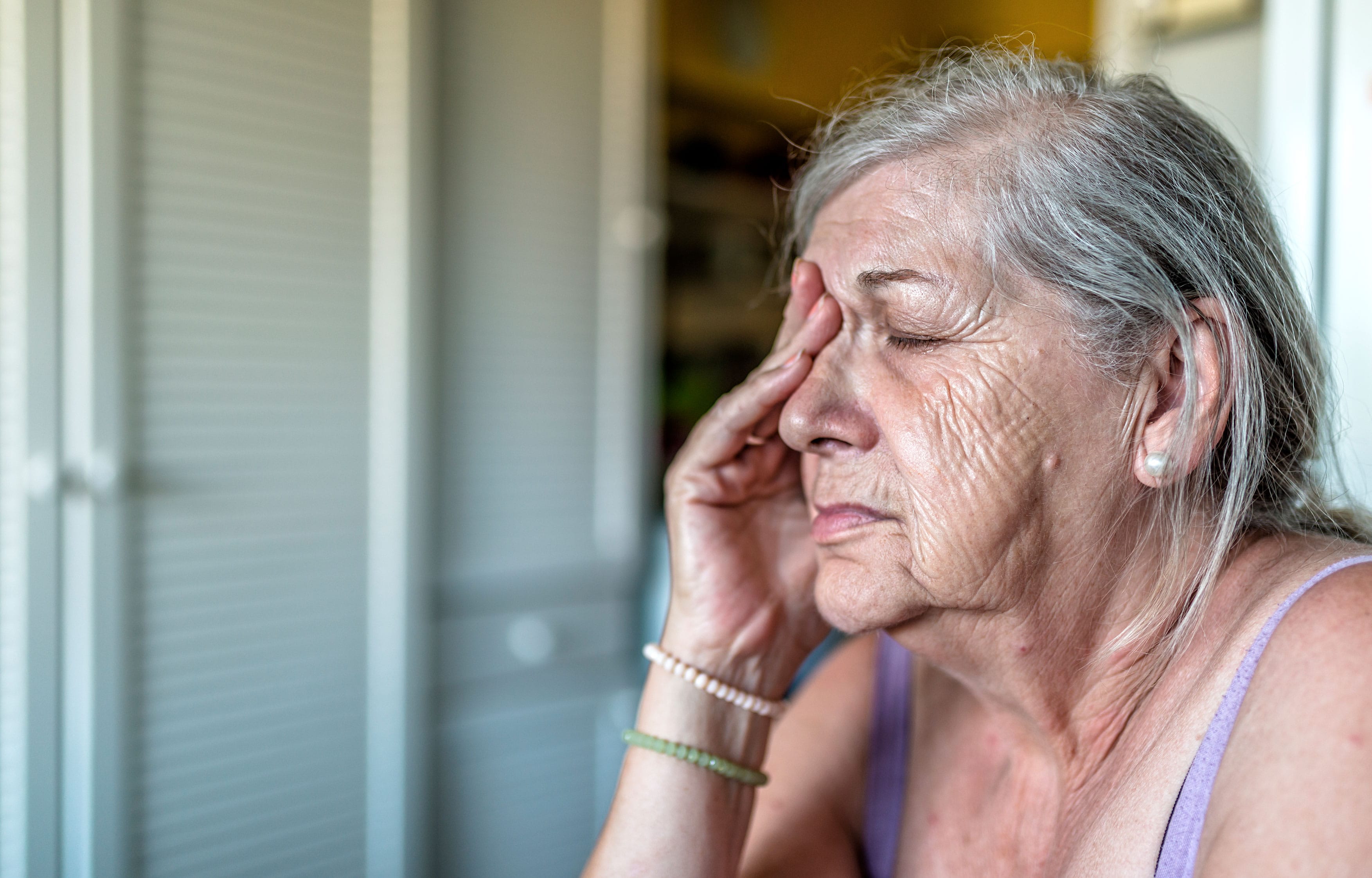 Stressed older woman touching face