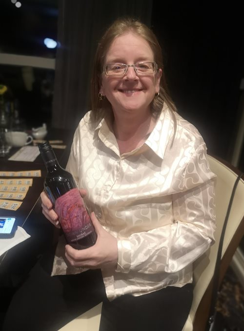 Bluebird Care Southend Registered Manager Kellie with a bottle of wine she won in the raffle