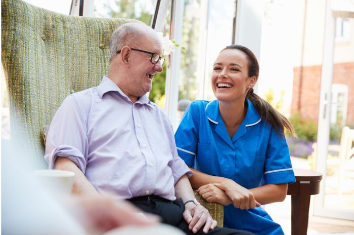 A care assistant and customer laugh and smile together