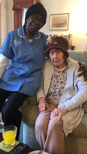 Bluebird Care live-in care assistant Charmaign, wearing a hat with a customer