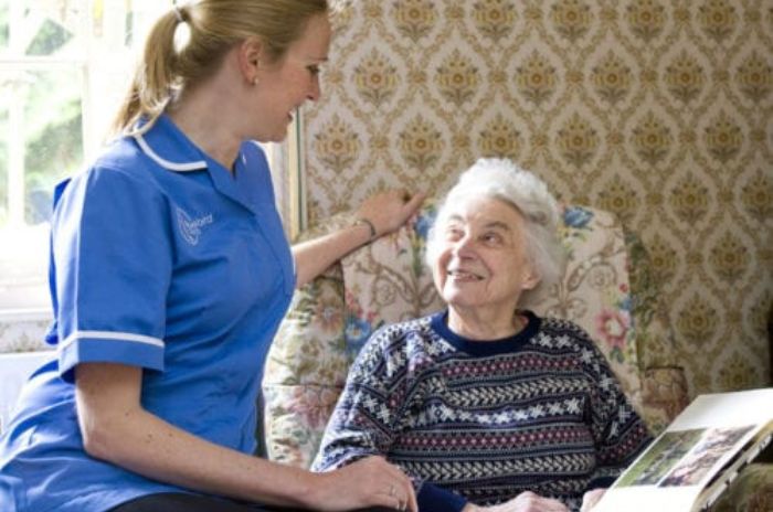 A care assistant looks after an elderly lady in her own home
