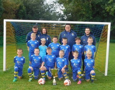 The Brompton Juniors Under Nine's Football Team, Standing in a Goal Wearing Their Sponsored Kit With Coaches