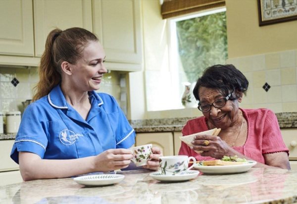 care worker having lunch with dementia patient