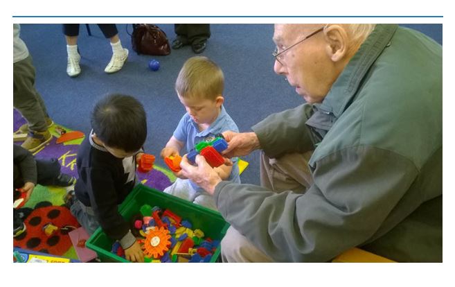 Bluebird Care customer playing with children from Exeter Road Primary school